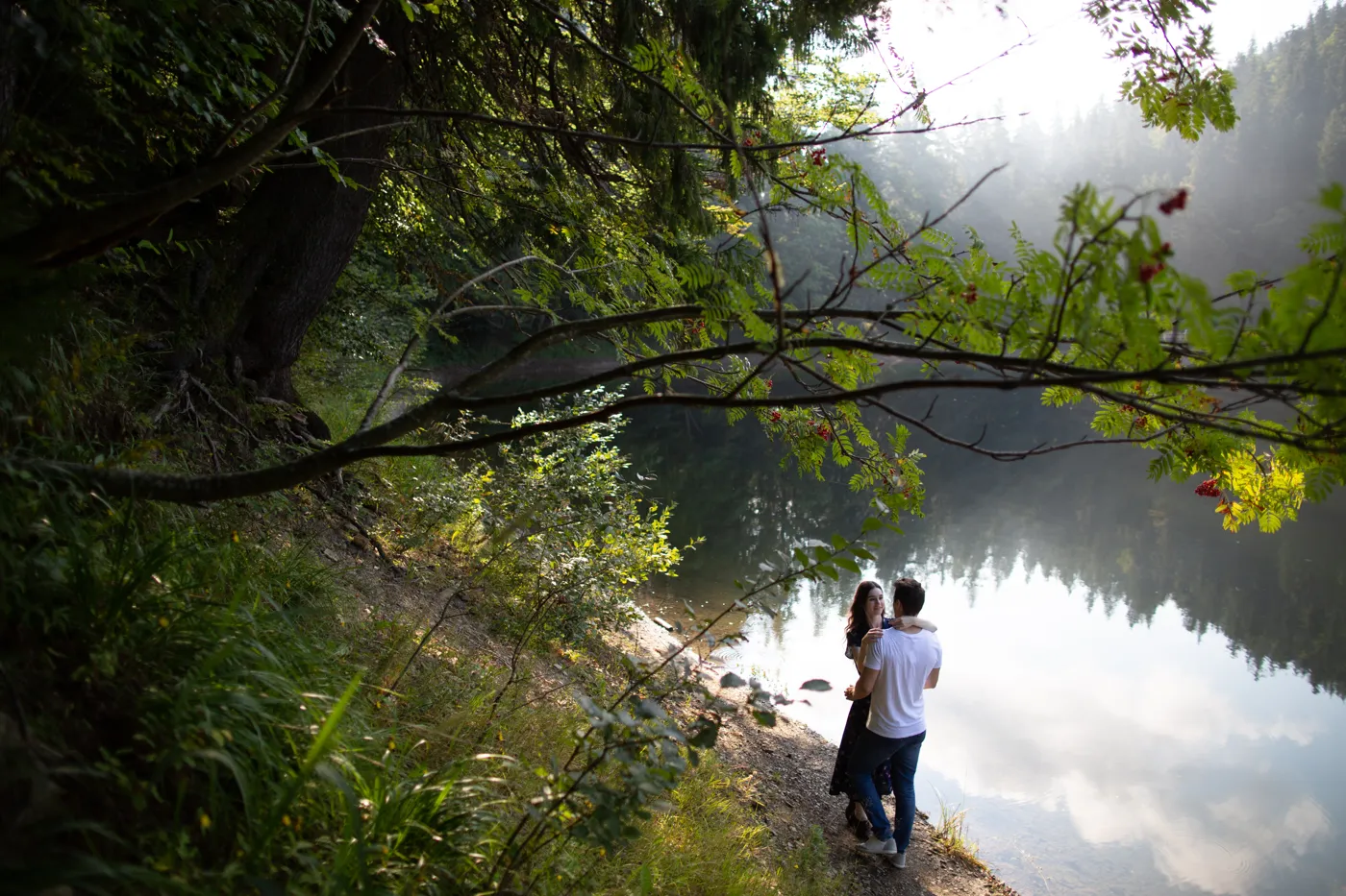 A couple embracing beside a calm lake